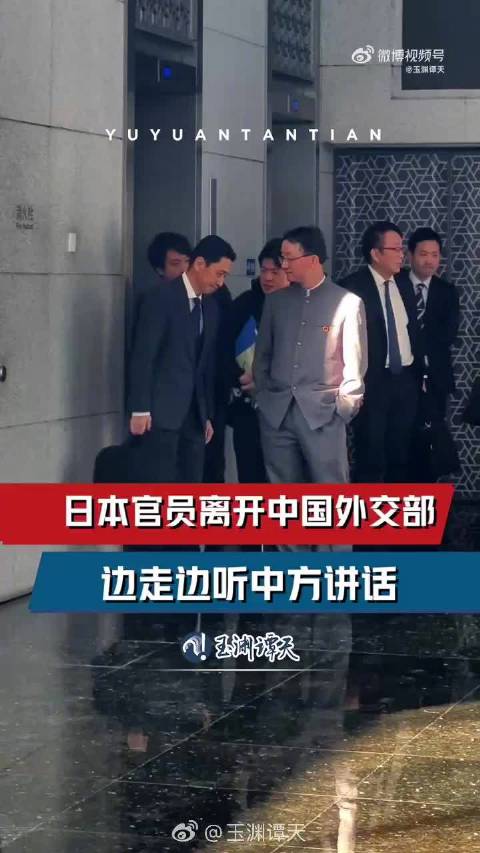 中方穿五四青年服胸前佩戴着国徽与日本官员会面